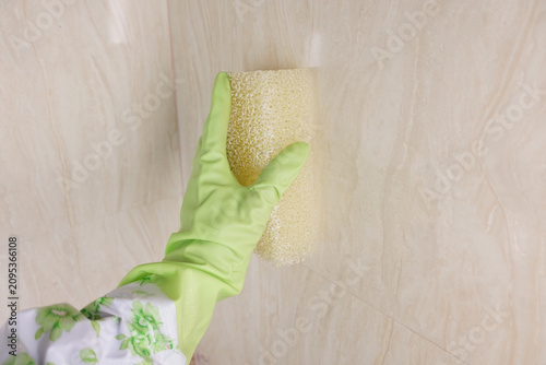 Photos Cleaning tiles with sponge in home on a weekday