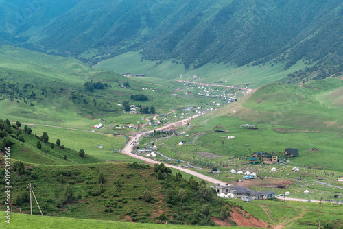 The Chon-Kurchak mountain valley with a yurt camp and a winding road in Kyrgyzstan.