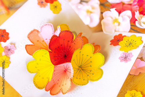 Fotografia Details of a handcraft paper flower in different colors and size sticked on a bl