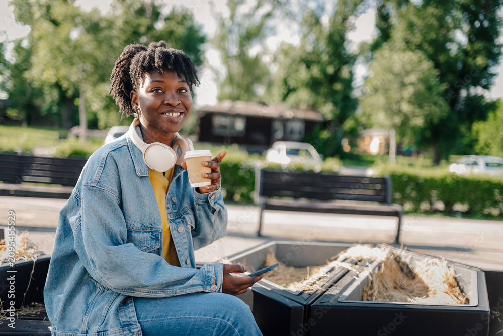 Fototapeta premium Happy young woman drinking coffee outdoors