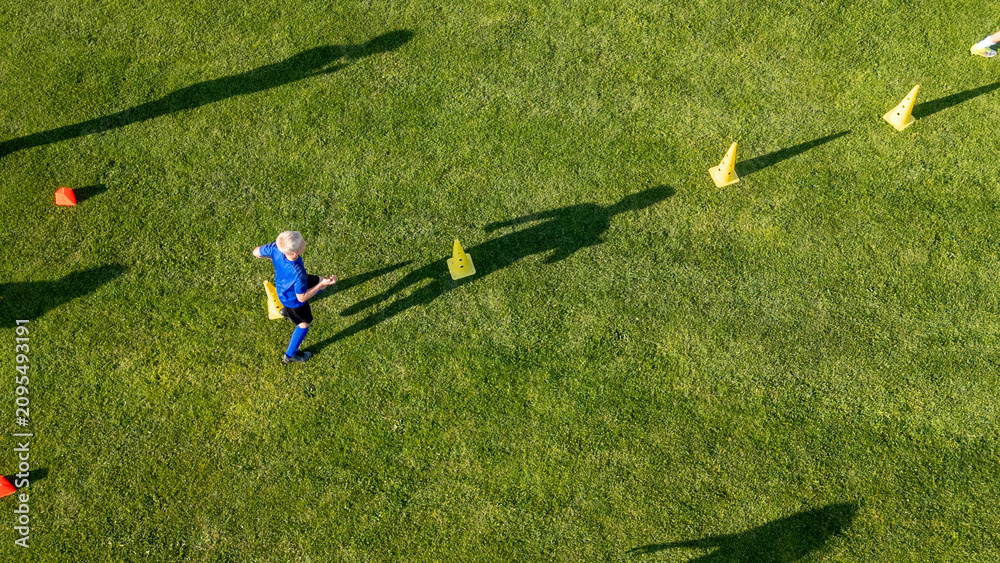 Fototapeta premium Areal view of football player running agility drills during soccer practice.