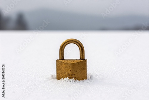 A vintage padlock on fresh snowfield