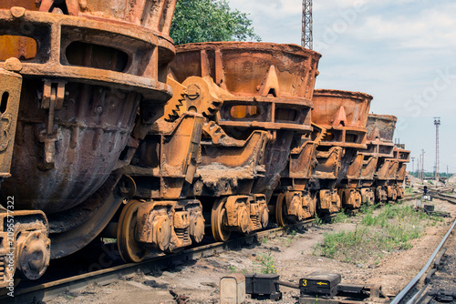Bild auf Leinwand Industrial ladles for transporting hot slag standing on railway tracks on a summ