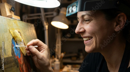 Woman art restorer using cotton swab on antique oil painting. Professional conservator cleaning surface of historic canvas. Detailed craftwork, museum preservation and restoration service