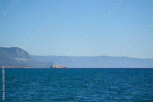Konstfotografi Cargo ship traveling through messina strait on a clear day