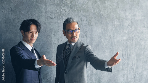 Foto 男性ビジネスパーソンのグループ。上司、部下、チームワーク、人材、経営、紹介、セミナー、仲介、ステージ