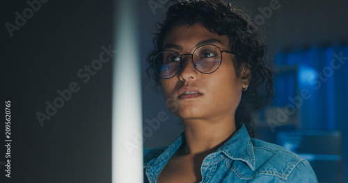Canvastavla Close-up Black female programmer with code reflection in glasses working late in home office at night
