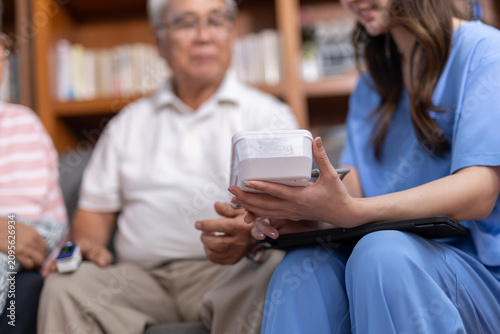Obraz na plátně Compassionate female nurse explaining medical device reading to attentive senior