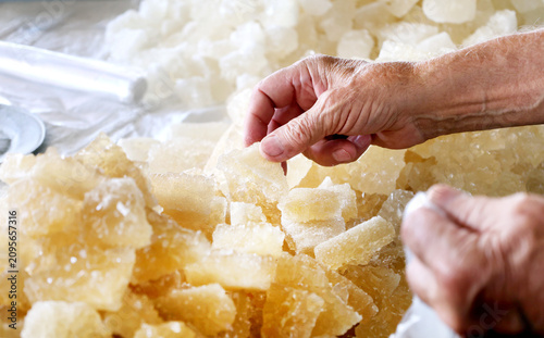 фотографія Customer selecting natural navvat rock sugar at a traditional market