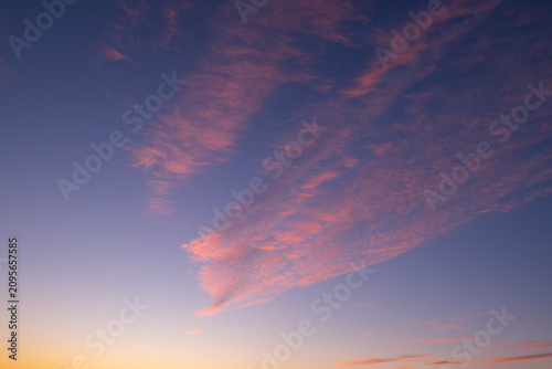 Foto Beautiful serene pink cloud formation floating in vast twilight blue sky during