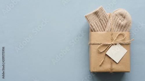 Gift box with beige socks tied with twine and blank tag