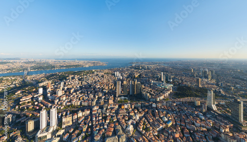Istanbul, Turkey. Panoramic aerial drone view of European part city skyline with modern skyscrapers and Bosphorus Strait at sunset, clear sky. Aerial view