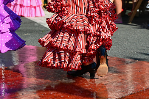 Fotografie Un personne habillée avec une robe de flamenco rouge rayée danse avec ses chauss