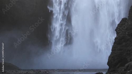 Mist rises at Skogafoss base as evening light fades establishing shot for nature docs, the Southern Region
