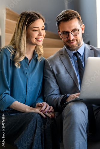 Two happy diverse multiethnic business team people working, talking in corporate office