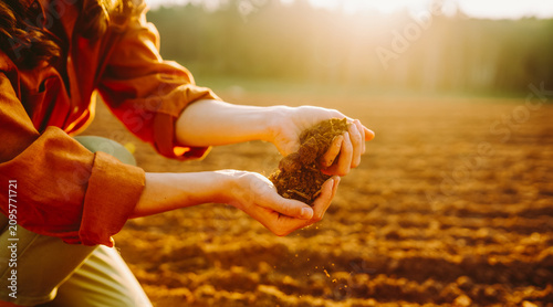 Foto Close-up of a female farmer's hands holding fertile soil in a field