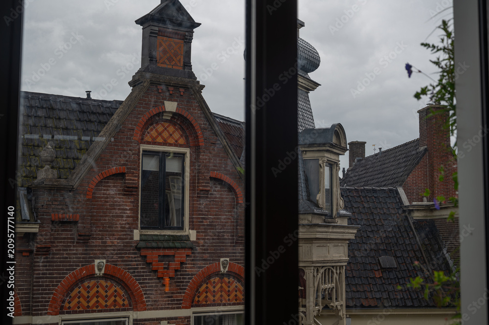 Obraz premium View of historic house facades in Assen, Netherlands from a window on a rainy day