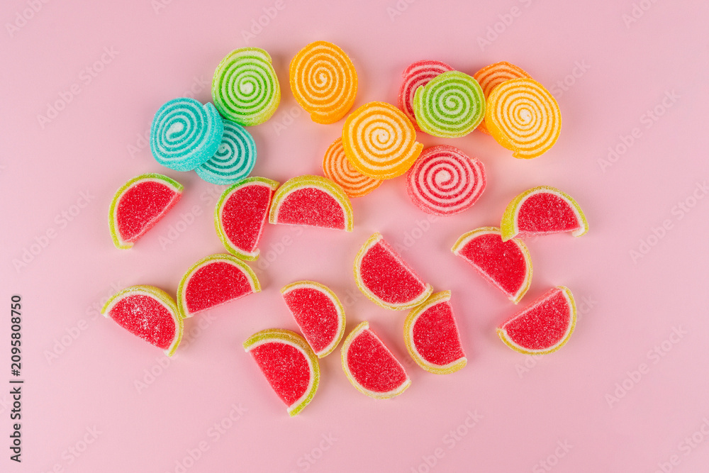 Fototapeta premium Colorful sugar-coated jelly candies against a pink background. 