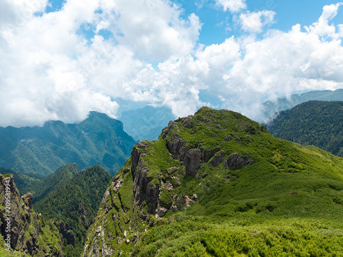 Photography Aerial view of Shennongjia National Park's lush green forests and rugged mountai