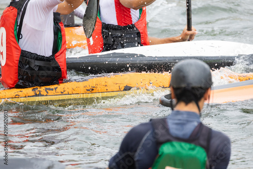 Konstfotografi Canoe polo players in colorful life jackets engage in competitive action on a ri