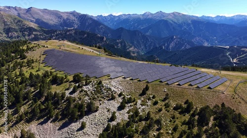 Wedge-shaped solar farm installed on a high alpine ridge above a ski piste, surrounded by pine forest with a sweeping Pyrenean mountain panorama, Andorra