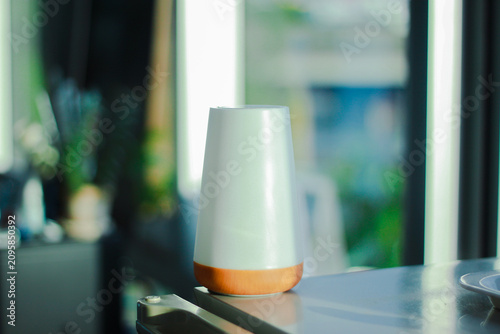 A modern white essential oil diffuser with a wooden base placed on a windowsill in soft natural light. Minimalist home decor creating a calm, relaxing atmosphere, perfect for wellness, aromatherapy, a