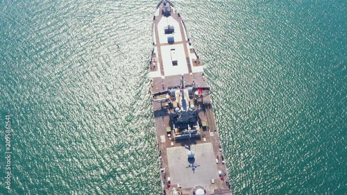 Amphibious Assault Ship. Navy aircraft carrier smoothly navigates serene blue ocean beneath brilliant sky. This powerful vessel demonstrates advanced naval technology and maritime strength