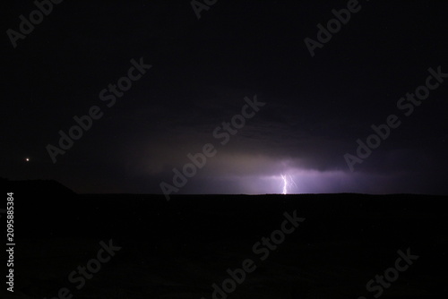 Canvastavla Tormenta eléctrica lejana con rayos sobre el horizonte y el planeta Venus brillando en el cielo nocturno
