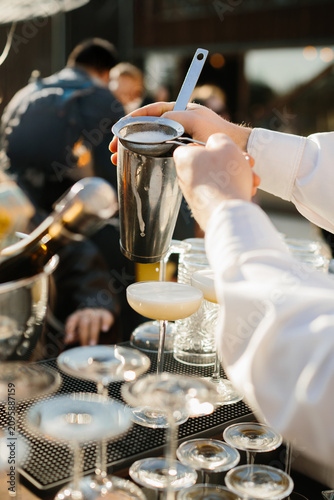 Bartender pouring cocktail into glass at celebration event