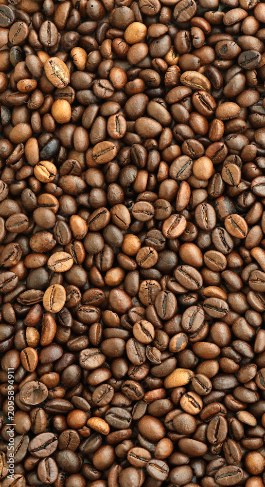 Fototapeta premium Detailed view on brown roasted coffee beans in big pile on table close up