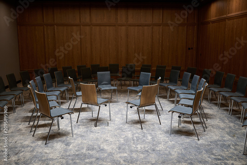 Close-up view of empty chairs arranged in a circle for a group therapy session or workshop inside a wood-paneled room, Gdansk, Pomerania, Poland, Europe