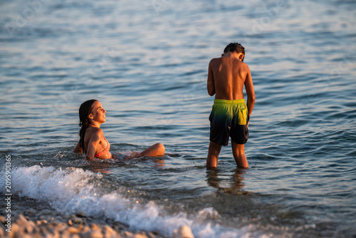 Konstfotografi Children playing in ocean waves during summer vacation
