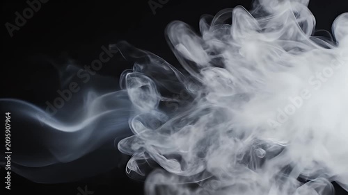 A swirling cloud of white smoke gracefully drifts against a stark black background, creating a captivating visual contrast.