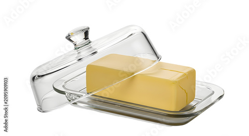 Sliced butter block on clear glass dish with stainless steel cutter on white background