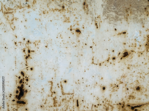 Speckled rusty metal texture background. Old white painted iron surface with pitted rust stains and corrosion dots. Distressed industrial backdrop.