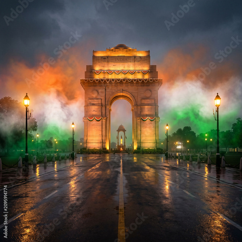 India Gate illuminated with saffron, white, and green smoke at dusk, Delhi