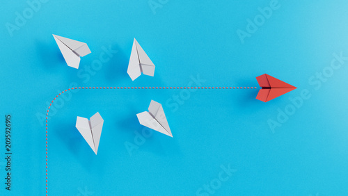Bild auf Leinwand A Single Red Paper Plane Takes A Separate Independent Flight Route