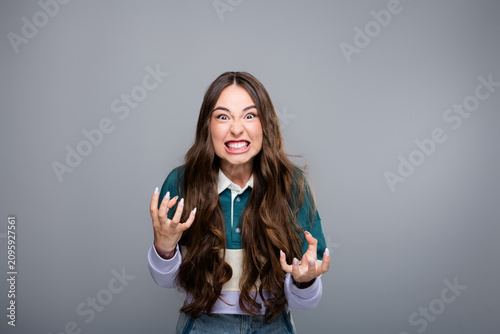 Obraz na plátně Frustrated young woman grimacing and clenching her hands in anger and annoyance