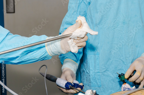 Surgeon wiping laparoscopic camera lens during minimally invasive surgery in operating room