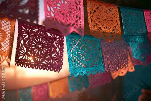 Colorful papel picado paper banners backlit by warm sunlight