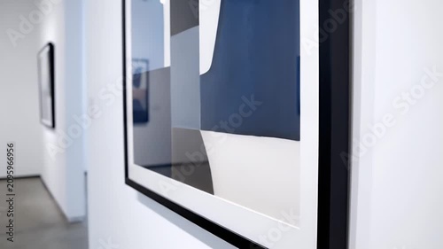 Modern art gallery with abstract paintings on wall.