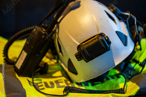 Fotografie Firefighter helmet with portable radio on high-visibility protective jacket
