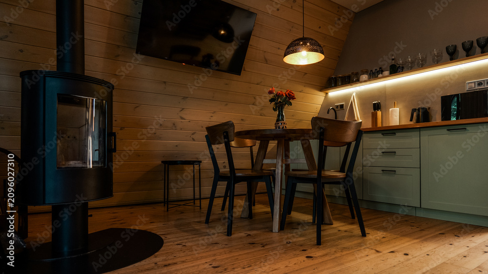 Obraz premium Cozy wooden cabin interior with dining area and modern kitchen