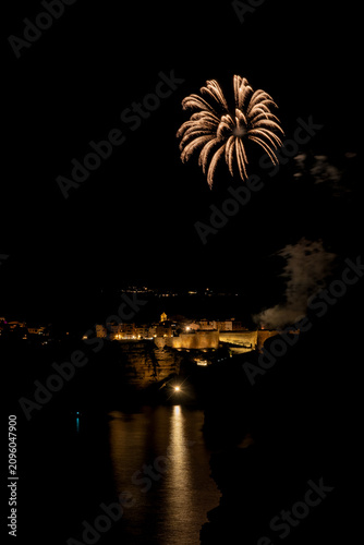 Fireworks exploding over Bonifacio citadel illuminating mediterranean sea
