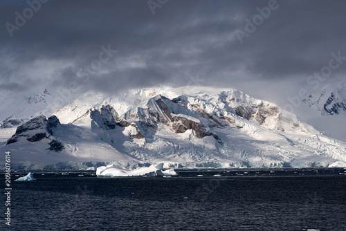 Snow-Covered Mountain on the Antarctic Coast. Zodiac Landing During an Antarctic Expedition Cruise. Antarctic Peninsula. Zodiac landing