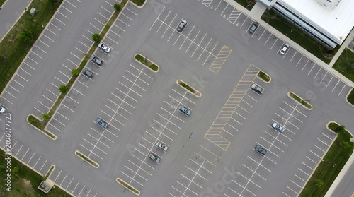 Aerial top down view of asphalt parking lot with cars