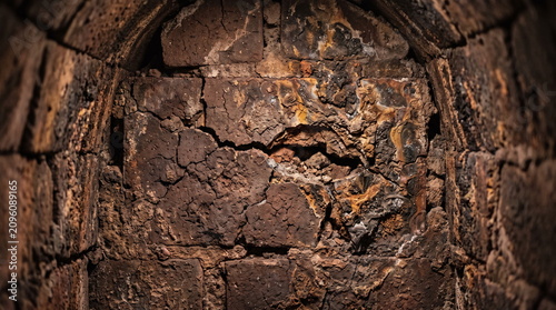 Damaged refractory brick lining inside an industrial metallurgical furnace with cracks and erosion
