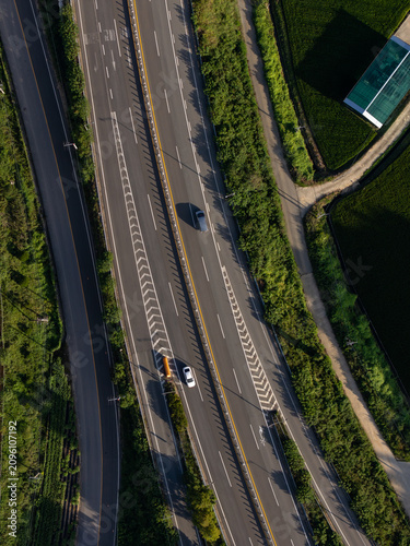 Canvastavla Aerial drone view of vehicle driving on green summer road