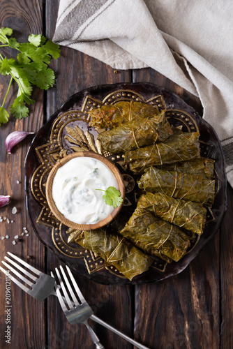 Delicious dolma (sarma), dolmades stuffed grape leaves rice, white yogurt sauce. Mediterranean Dolma. Lebanon turkish greek middle eastern cuisine. View from above.
