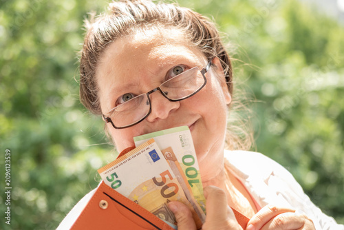 Cuadro en lienzo overweight mature woman holding orange wallet with 50 and 100 euro banknotes, sm